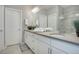Well-lit bathroom with double sinks, white cabinets, and ample countertop space at 11568 Dewey St, Parker, CO 80138