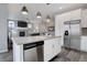Modern kitchen island with stainless steel appliances and a cozy living room view at 11568 Dewey St, Parker, CO 80138