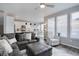 Open-concept living area showcasing a large sofa, bright windows, and a view into the modern kitchen at 11568 Dewey St, Parker, CO 80138