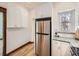 Renovated kitchen with stainless steel refrigerator and complementing white cabinets at 2411 N High St, Denver, CO 80205