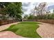 Landscaped backyard with artificial turf, gravel, and a fence for added privacy at 8240 Grandview Ave, Arvada, CO 80002