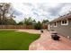 Spacious backyard with artificial grass, gravel landscaping, a patio, and a fire pit at 8240 Grandview Ave, Arvada, CO 80002