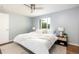 Bright bedroom with a plush bed, ceiling fan, neutral decor, and ample natural light from the large window at 8240 Grandview Ave, Arvada, CO 80002