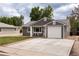 Charming home with a driveway, garage and well-maintained lawn with seating area in front of large picture window at 8240 Grandview Ave, Arvada, CO 80002