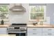 Modern kitchen with white cabinets, stainless steel appliances, butcher block countertops, and subway tile backsplash at 8240 Grandview Ave, Arvada, CO 80002