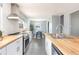 Well-lit kitchen features butcher block counters, stainless appliances, and a view to the dining area at 8240 Grandview Ave, Arvada, CO 80002