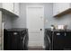 Convenient laundry room with modern appliances, storage cabinets, and stylish decor at 8240 Grandview Ave, Arvada, CO 80002