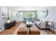 Inviting living room with stylish furniture, hardwood floors, and bright natural light pouring in through large windows at 8240 Grandview Ave, Arvada, CO 80002