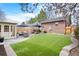 A serene backyard featuring an artificial lawn, patio, and outdoor seating area perfect for relaxation and entertaining at 3336 W 35Th Ave, Denver, CO 80211