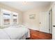 Bedroom features hardwood floors, a white bed, and a view to the outside at 3336 W 35Th Ave, Denver, CO 80211