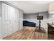This is a bedroom space with wood floors, a blue sofa, and closet at 3336 W 35Th Ave, Denver, CO 80211