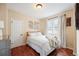 A cozy bedroom offers hardwood floors, a plush white bed, and natural light at 3336 W 35Th Ave, Denver, CO 80211