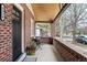 A cozy front porch with brick accents, seating, and a potted plant offers a welcoming entrance to the home at 3336 W 35Th Ave, Denver, CO 80211