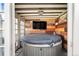 A covered hot tub area with wood-paneled walls, a TV, and rustic decor creates a cozy relaxation space at 3336 W 35Th Ave, Denver, CO 80211