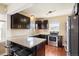 Well-lit kitchen featuring stainless steel appliances, granite counters, and dark cabinets at 3336 W 35Th Ave, Denver, CO 80211