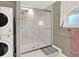 Modern bathroom featuring a walk-in shower with glass doors and convenient washer and dryer at 638 S Dudley St, Lakewood, CO 80226