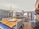Open-concept dining and kitchen area with a large wooden table, gray cabinets, and stainless appliances at 638 S Dudley St, Lakewood, CO 80226