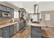 Well-lit kitchen featuring stainless steel appliances, gray cabinets and a modern hood vent at 638 S Dudley St, Lakewood, CO 80226