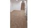 Finished basement area with neutral carpet, stairs, and door to storage, creating a versatile living space at 6521 Zinnia St, Arvada, CO 80004