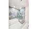 Updated bathroom featuring custom tile work in shower, with glass partition, and white soaking tub at 6521 Zinnia St, Arvada, CO 80004