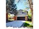 Inviting two-story home with a spacious driveway, brick accents, and an attached two-car garage at 6521 Zinnia St, Arvada, CO 80004