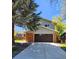 Inviting two-story home with a spacious driveway, brick accents, and an attached two-car garage at 6521 Zinnia St, Arvada, CO 80004