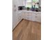 White cabinetry and wooden floors add brightness and space to this modern-designed kitchen at 6521 Zinnia St, Arvada, CO 80004