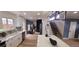 Renovated kitchen with white cabinets, a large island, and an open view to the living area at 6521 Zinnia St, Arvada, CO 80004