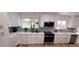 Bright kitchen with white cabinets, stainless steel appliances, and decorative backsplash tiles at 6521 Zinnia St, Arvada, CO 80004