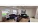 Bright living room with dark furniture, neutral paint, and new wooden floors at 6521 Zinnia St, Arvada, CO 80004
