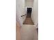 View looking down the staircase with neutral carpet, black railing, and access to lower level with tile entry at 6521 Zinnia St, Arvada, CO 80004
