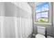 Bathroom featuring a shower-tub combo with a white curtain and a toilet at 15547 W Vassar Ave, Lakewood, CO 80228