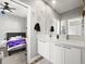 Modern bathroom with double vanity, white cabinets, and views into adjacent bedroom at 15547 W Vassar Ave, Lakewood, CO 80228