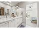 Bright bathroom boasts double sinks, modern fixtures, and a view into the main bedroom at 15547 W Vassar Ave, Lakewood, CO 80228