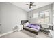 Bedroom featuring a desk, a bed with purple comforter, and a well-lit room at 15547 W Vassar Ave, Lakewood, CO 80228