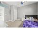 Bedroom featuring a ceiling fan, plush carpet, and a bed with a purple comforter at 15547 W Vassar Ave, Lakewood, CO 80228