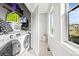 Bright laundry room featuring new washer and dryer units, storage, and a window at 15547 W Vassar Ave, Lakewood, CO 80228