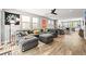Spacious living room featuring a sectional sofa, modern ceiling fan, and view into the kitchen at 15547 W Vassar Ave, Lakewood, CO 80228