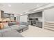Open concept living room featuring a gray sofa, kitchen, built-in desk, and staircase at 15547 W Vassar Ave, Lakewood, CO 80228