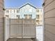 View of the blue apartment building and gated yard at 5888 Biscay St # D, Denver, CO 80249