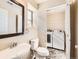 Half bath featuring modern vanity, mirror, and in-unit laundry area at 5888 Biscay St # D, Denver, CO 80249