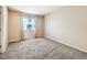 Bright bedroom features plush carpet, neutral walls, and a window for natural light at 5888 Biscay St # D, Denver, CO 80249