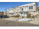 A row of tan townhomes with blue doors in a shared complex during the winter at 5888 Biscay St # D, Denver, CO 80249