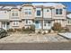 Inviting townhome featuring a well-maintained lawn, reserved parking and charming blue doors at 5888 Biscay St # D, Denver, CO 80249