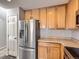 Bright kitchen features stainless refrigerator, light wood cabinets, and neutral countertop at 5888 Biscay St # D, Denver, CO 80249