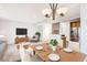 Cozy living room featuring a dining table, a chair, a TV, and a view into the kitchen at 5888 Biscay St # D, Denver, CO 80249