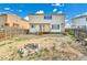 Backyard featuring a fire pit, wooden fence, and two story house at 21455 E 44Th Ave, Denver, CO 80249