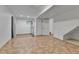 Unfinished basement space with tile flooring, exposed beams, and a door at 21455 E 44Th Ave, Denver, CO 80249
