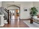 Welcoming foyer with brick archway, hardwood floors, stairs with wrought iron railing, and view of the kitchen at 21455 E 44Th Ave, Denver, CO 80249
