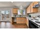 Modern kitchen with granite countertops, wood cabinets, stainless sink, stylish faucet, and backyard access at 21455 E 44Th Ave, Denver, CO 80249